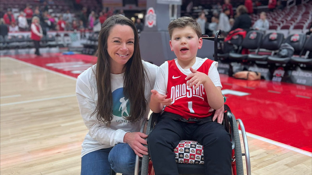 Dr. Bradbury poses with Landon in his wheelchair on the basketball court