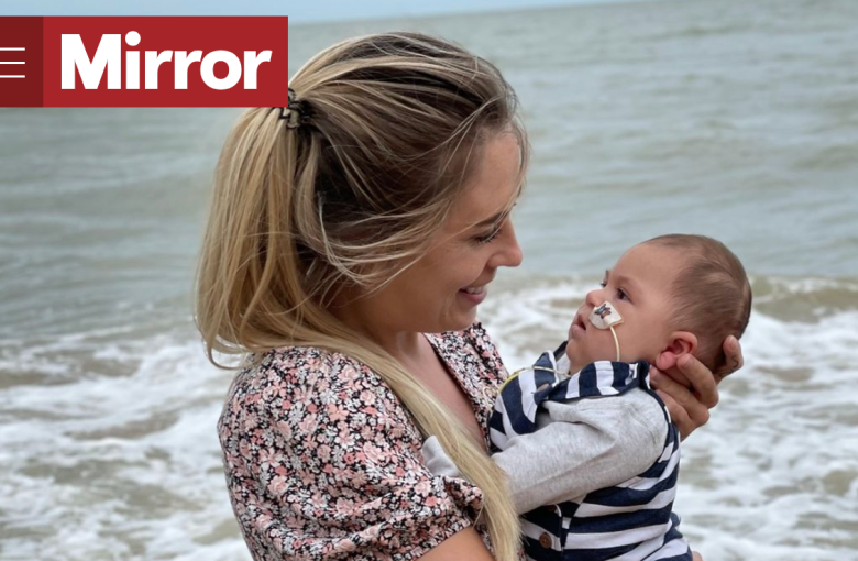 Lucy holding Leo on the beach