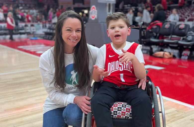 Dr. Bradbury poses with Landon in his wheelchair on the basketball court
